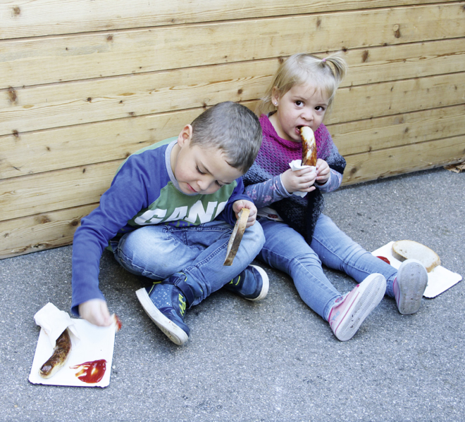 Kleine Kinder essen Bratwurst an der Gewerbeausstellung Stärne füfi in Beromünster