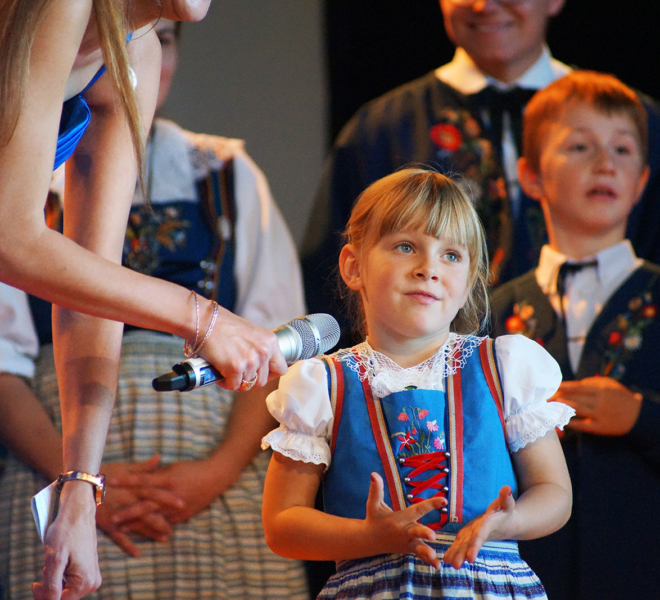 Nicole Galliker interviewt ein Kind der Trachtengruppe Gunzwil