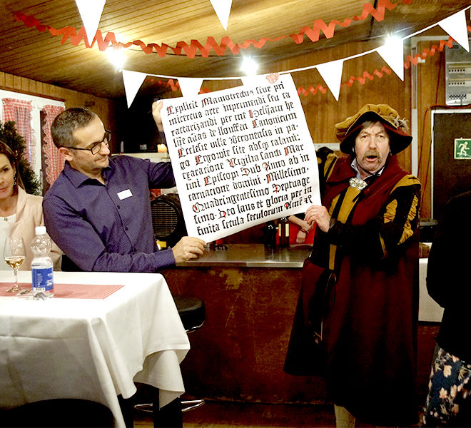 Ludwig Suter und Adrian Polesel überreichen ein Text gebührend der Wallimann Druck und Verlag AG.